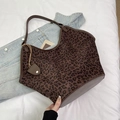Vista dettagliata della borsa tote leopardata marrone con finiture in pelle e pendente - Stampa leopardata