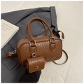 Gros plan d'un sac Boston tressé avec mini pochette sur fond de costume gris - Marron