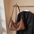 Close-up of brown suede hobo bag with bohemian beaded charm on a suit background - Coffee With Pendant