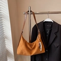 Close-up of brown suede hobo bag with adjustable strap and wooden bead charm detail - Brown with Pendant