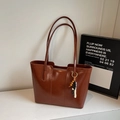 Detalle del bolso tote de cuero marrón brillante con colgante de cuentas y costuras - Marrón con Colgante