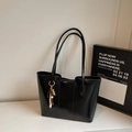 Detalle del bolso tote negro brillante con costuras verticales y colgante de madera - Negro Con Colgante