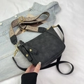 Detalle de bolso bandolera negro con correa ancha de estilo étnico y cierres dorados - Negro
