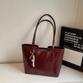 Detalle del bolso tote burdeos con textura de cuero brillante y dije de cuentas retro - Vino Tinto con Colgante