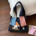 Dettaglio del ricamo con casa a fungo e coniglio sulla borsa tote in denim blu - Blu Denim