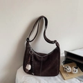 Detail einer großen dunkelbraunen Wildleder-Hobo-Tasche mit weißen Ziernähten - Mit Anhänger / Kaffeebraun