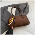 Detail einer braunen matten Bowlingtasche mit buntem Holzperlen-Quastenanhänger - Kaffee Mit Anhänger
