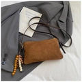 Detail einer braunen Vintage-Wildleder-Einkaufstasche mit dekorativem Perlen-Quasten-Akzent - Braun mit Anhänger