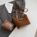 Detail der dunkelbraunen Wildleder-Beuteltasche mit Innentasche auf grauem Blazer - Braun