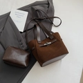Detail der dunkelbraunen Wildleder-Beuteltasche mit Silberverschluss und kleiner Tasche - Braun