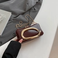 Dettaglio borsa in pelle bordeaux con anello in metallo a forma di C dorato e catena - Marrone