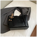 Top view of black leather tote bag with vintage texture and cute bunny charm on white fabric - Black With Pendant