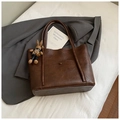 Detail view of retro brown tote bag with a stylish rabbit charm on a neutral background - Coffee With Pendant