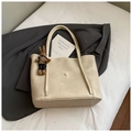 Close-up of cream tote bag with matte texture, shoulder strap and plush bunny charm - Cream White with Pendant