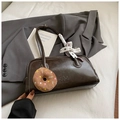 Close-up of retro brown shoulder bag with white stitching and decorative silk scarf - Brown