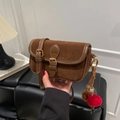 Gros plan du sac bandoulière en daim marron avec boucle en métal rétro et pompons en peluche - Marron avec Pendentif