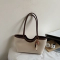 Detail view of woven tote bag with wavy edge design and ethnic style wooden bead charm - With Pendant / Off White