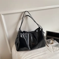 Glossy black faux leather tote bag with long straps shown in a modern office setting - Black
