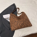Dettaglio della borsa tote in tela leopardata con tracolla larga su sfondo bianco - Marrone leopardato