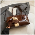Glossy brown tote bag with bear charm and golden logo on a stylish grey blazer - Brown with Pendant