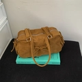 Braune Wildledertasche mit Schleifendetail und Kordelzug auf grünem Buch - Braun