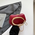 Detalle del mini bolso rojo mate con su exclusivo asa de metal dorado de forma ovalada - Rojo