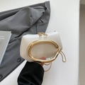Detalle de mini bolso de cuero blanco con asa metálica en forma de C dorada y cremallera - Blanco