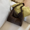 Detail of leopard print fabric tote bag with decorative knot handle on cream sofa - Brown