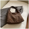 Detailansicht der dunkelbraunen Hobo-Tasche mit matter Vintage-Textur und Gold-Logo - Braun