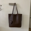 Dettaglio della borsa tote in pelle marrone scuro con trama litchi e piccola tasca tonda - Marrone