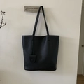 Dettaglio della borsa tote in pelle martellata nera con manici sottili e ciondolo - Nero