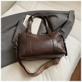 Detail view of coffee brown Boston bag with bohemian woven shoulder strap and PU leather texture - Brown / Small