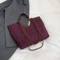 Paarse gewatteerde tote bag met gouden ketting op een zachte witte stoffen achtergrond - Rood