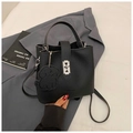 Détail du sac seau noir en cuir grainé avec fermoir argenté et breloque en forme de chien - Noir
