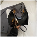 Minimalistische schwarze Halbmond-Schultertasche mit goldenen Details und Quasten - Schwarz mit Anhänger