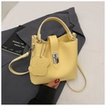 Détail du sac seau jaune en cuir grainé avec charme de chien et fermoir en métal doré - Jaune
