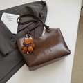 Borsa tote in pelle marrone scuro con manici lunghi e ciondolo a forma di orso su sfondo bianco - Marrone con ciondolo