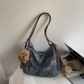 Detail van donkergrijze hobo-tas met bruine leren riemen en pluchen beer hanger - Blauw met hanger