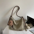 Detail van vintage canvas tas met bruine leren riemen en een teddybeertje hanger - Off-white Met Hanger