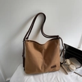 Détail d'un sac cabas en toile marron avec bandoulière réglable et étiquette de marque - Marron
