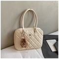 Detalle de bolso tote acolchado beige con logo metálico y un lindo colgante de peluche - Blanco Roto Grande Con Colgante