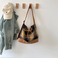 Detail van de grote vintage ruitjes tas met bruine lederen randen en een strik als accent - Geel