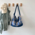 Detail van blauwe geruite canvas draagtas met verstelbare riem en decoratieve knoop - Blauw