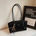 Detalle del bolso tote con estampado de leopardo gris, logo dorado y llavero trenzado - Negro