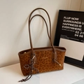 Detalle del bolso tote vintage con estampado de leopardo, correas marrones y accesorio - Marrón