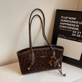 Detalle del bolso tote con estampado de leopardo oscuro, correas dobles y logo de moda - Marrón