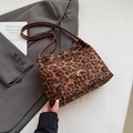 Leopard print tote bag with golden bow ornament on gray suit jacket background - Leopard Print