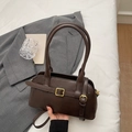 Vintage dark brown minimalist tote bag with golden buckles on a white bed - Coffee
