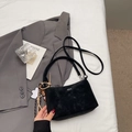 Detailed top view of black suede bucket bag with cloud charm on white sheets - Black With Pendant