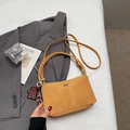Detail of mustard yellow vintage bucket bag with leopard print heart pendant on a white sheet - Khaki With Pendant